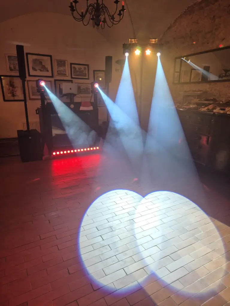 DJ pult s nasvícením parketu pod klenbou historického sklepa.